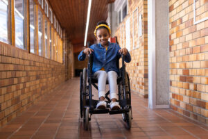 imagem ilustrativa de criança com diplegia espástica, sentada em uma cadeira de rodas