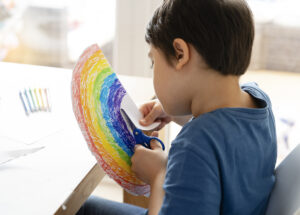 imagem ilustrativa de criança pintando um arco-íris